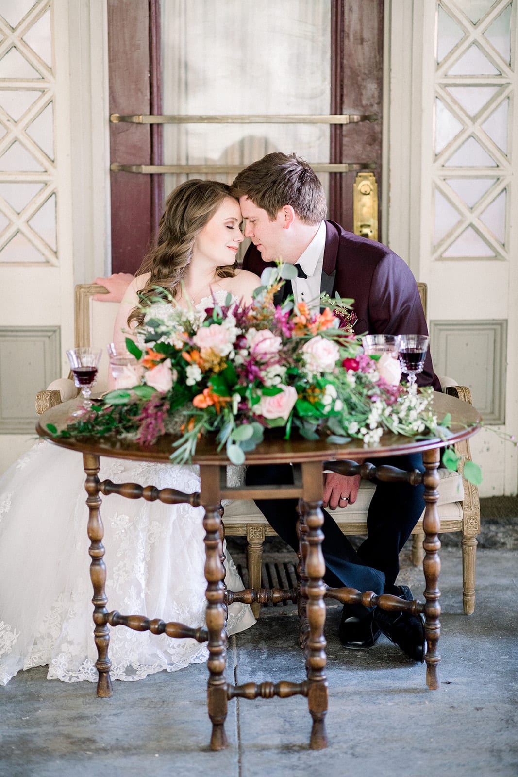 Wedding Couple at a sweetheart table. Table is a vintage gate leg table in an oval shape.